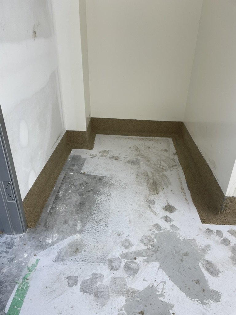 Epoxy cove base being applied at a wall-floor junction