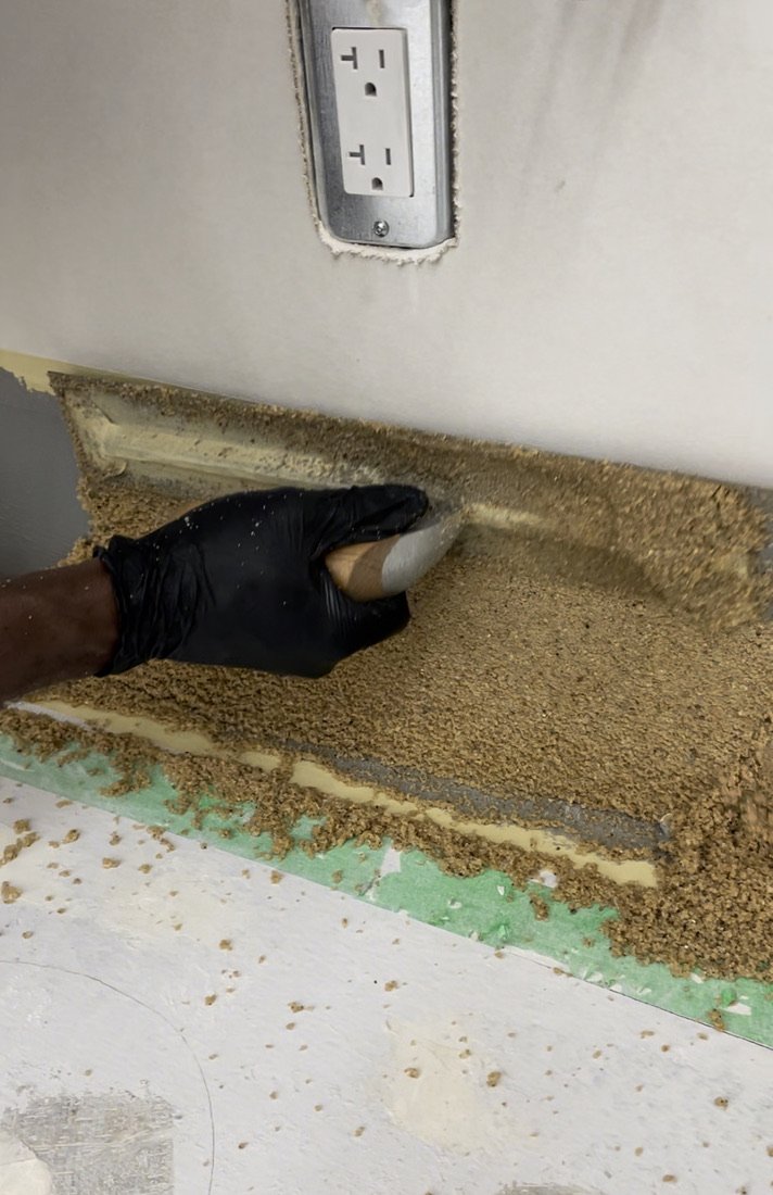 Epoxy cove base being hand-troweled onto a wall