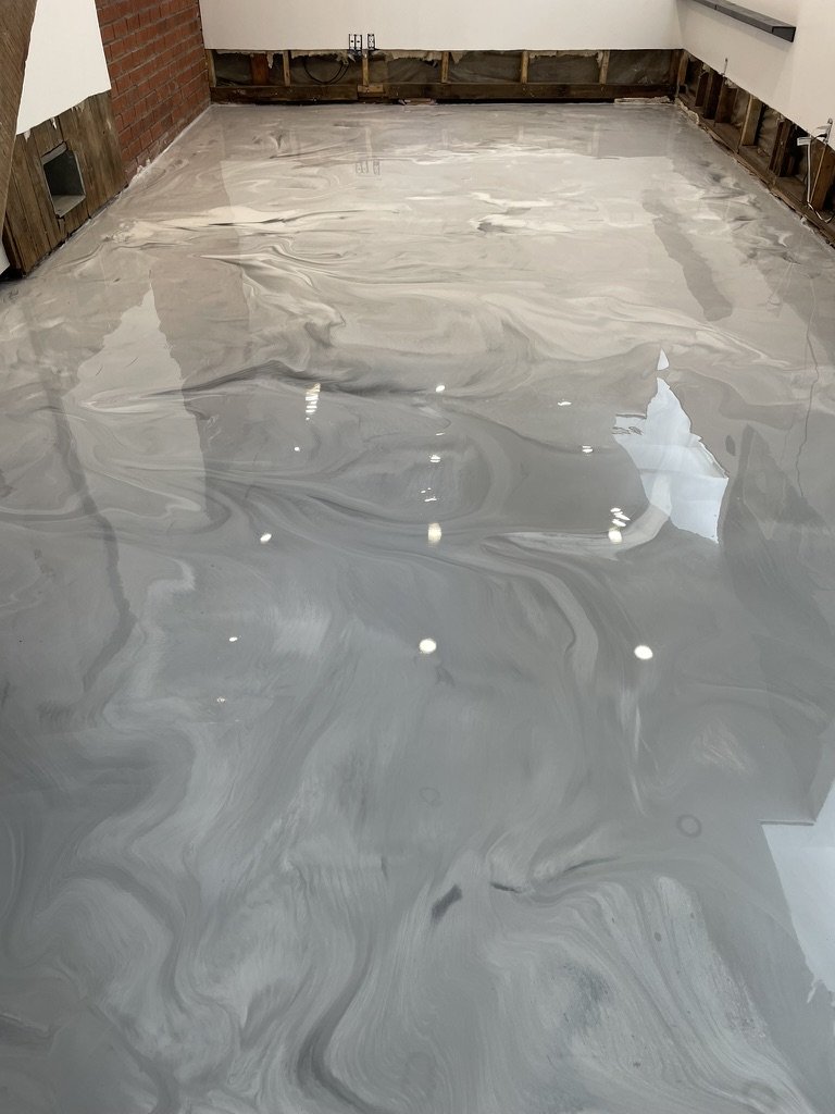 Silver-gray metallic epoxy floor, exposed brick basement